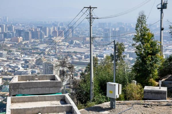 Santiago in the distance from a hill, in the foreground are electricity power lines